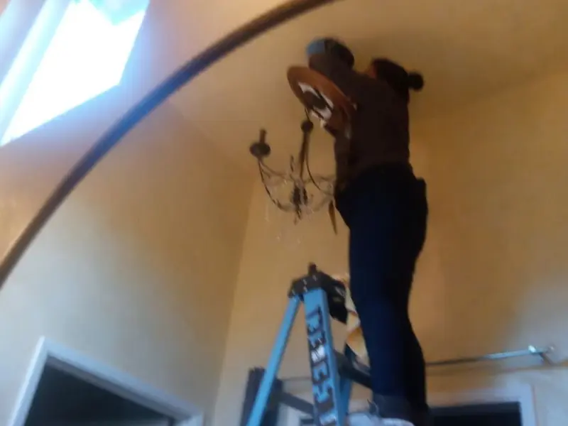 Electrician installing a chandelier in a Arroyo Grande residence